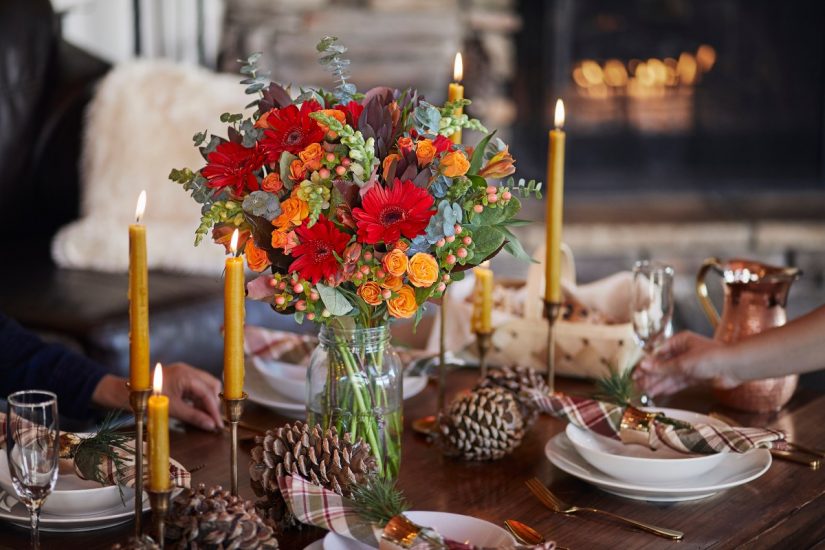 Virtual Thanksgiving Decor. Tablescape with floral centerpiece, pinecones and candles.