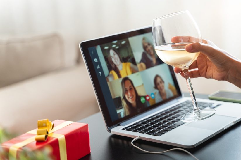 Virtual Thanksgiving Toast. Person holding a glass of wine and making a toast while on a video-call 