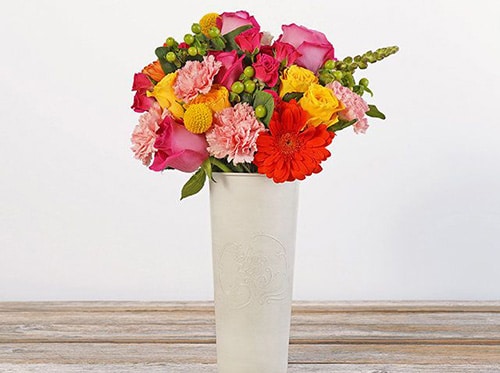 bright and cheerful bouquet with red, pink, yellow flowers with greenery.