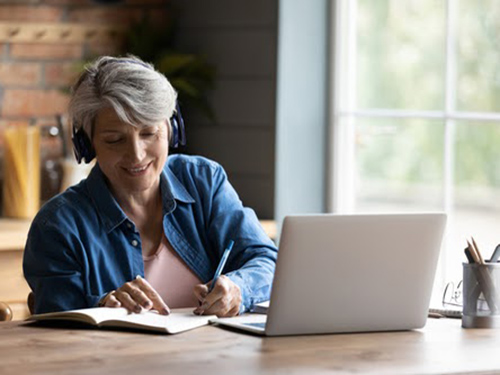 Woman with headphones on a laptop call.