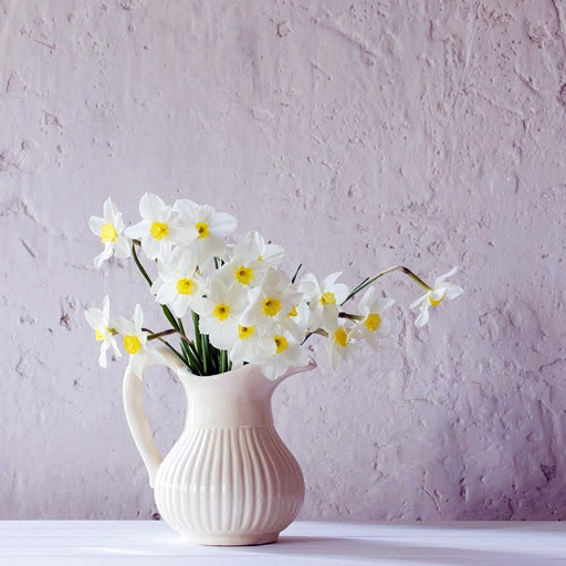 White ceramic pitcher with yellow and white flowers.