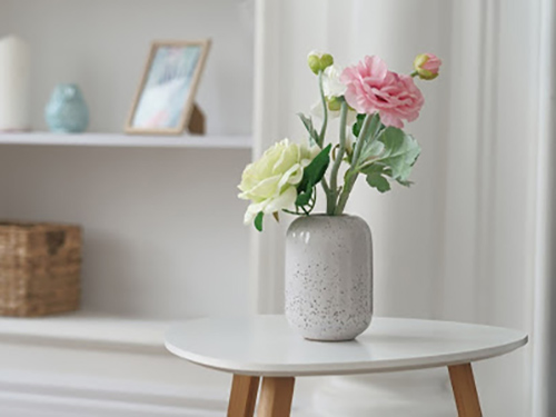 Vase with flowers against white background.