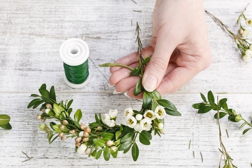 Applying floral twine to stems in preparation for a flower crown