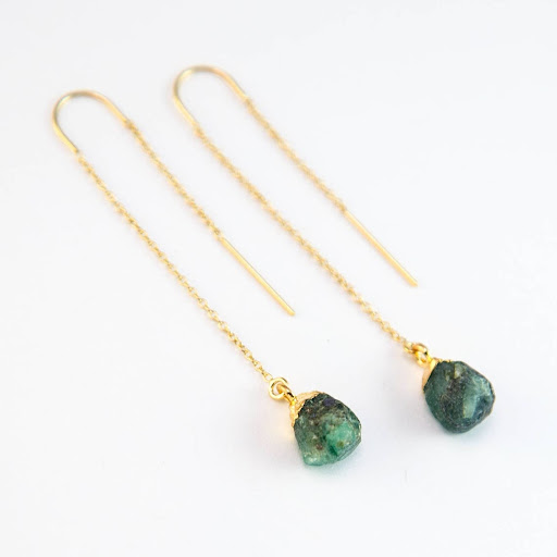 green gemstone earrings on gold chains