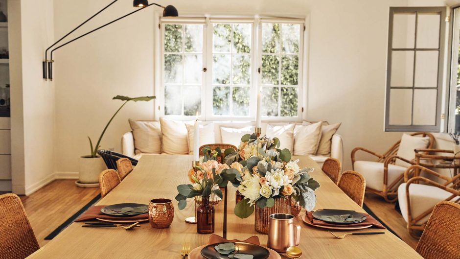 white and peach flowers in a copper vase on a dining room table