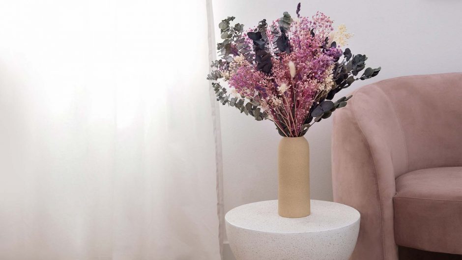 dried purple flower bouquet in a taupe vase