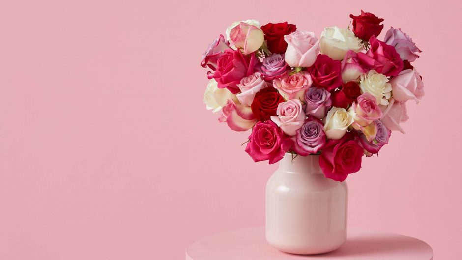 Red, pink and white roses in a pink vase