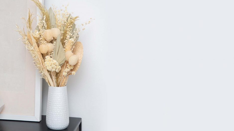 white dried flowers in a white vase