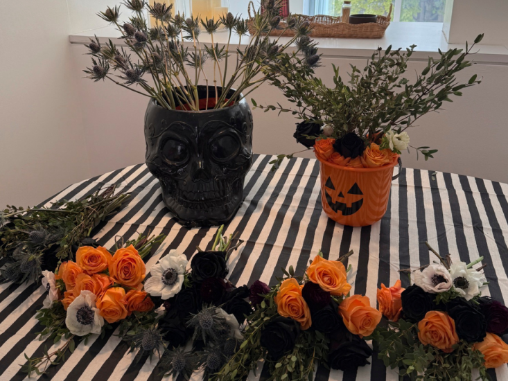 Various bouquets of spooky flowers laid out on a table with extra flowers in spooky vases.