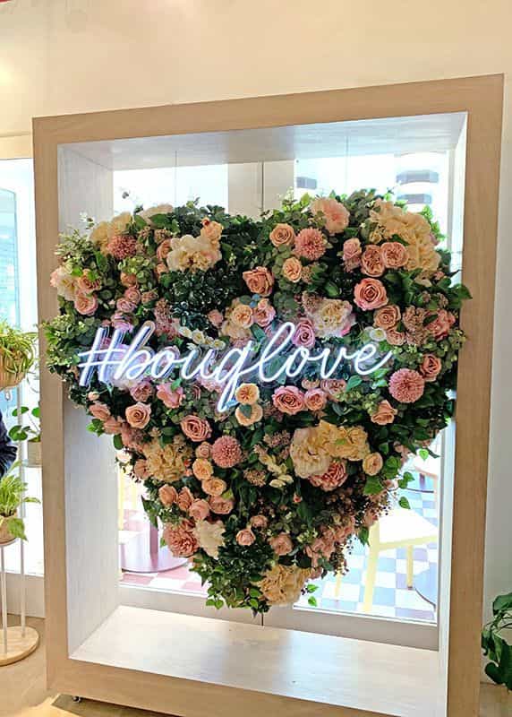 Flower installation in the shape of a heart with hashtag #bouqlove