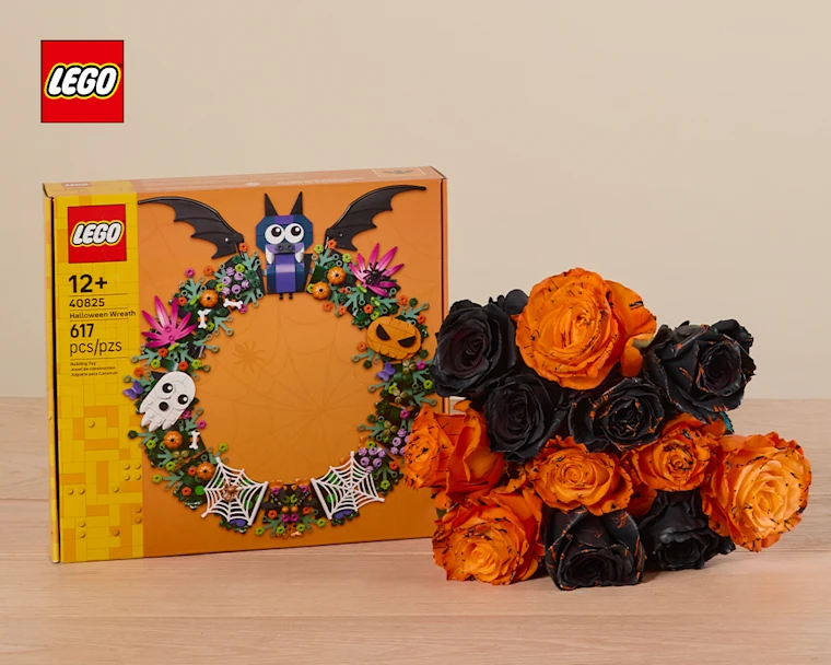 halloween themed lego wreath next to orange and black roses