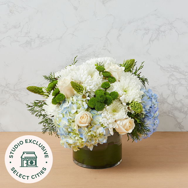 White and green flower arrangement with blue hydrangeas