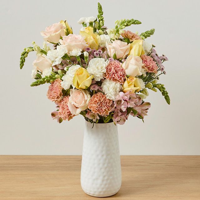 A colorful bouquet in a white vase.