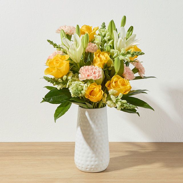 A colorful bouquet in a white vase.