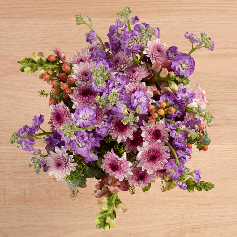 Flower assortment of snaps, hypericum, and poms in peach, pink and lavender.