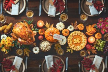 An overhead shot of a Thanksgiving table filled with food and dinnerware.
