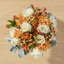 Ivory roses bouquet with bronze pompons, peach hypercium and orange alstroes. 