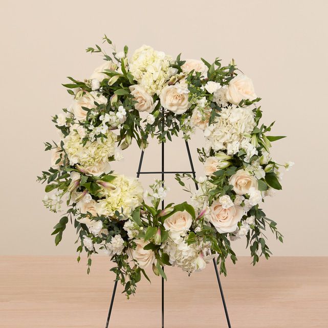 mixed floral wreath in white with roses, hydrangeas, and lush greenery