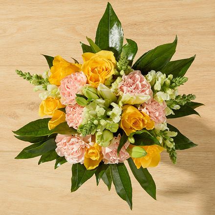 Bouquet featuring peach carnations, yellow roses and white lilies.